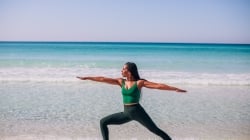 woman doing yoga pose on beach